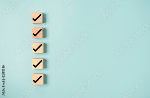 Black correct sign and tick check mark to wooden cube block with copy space for checklist of ISO quality control and approve business product concept.