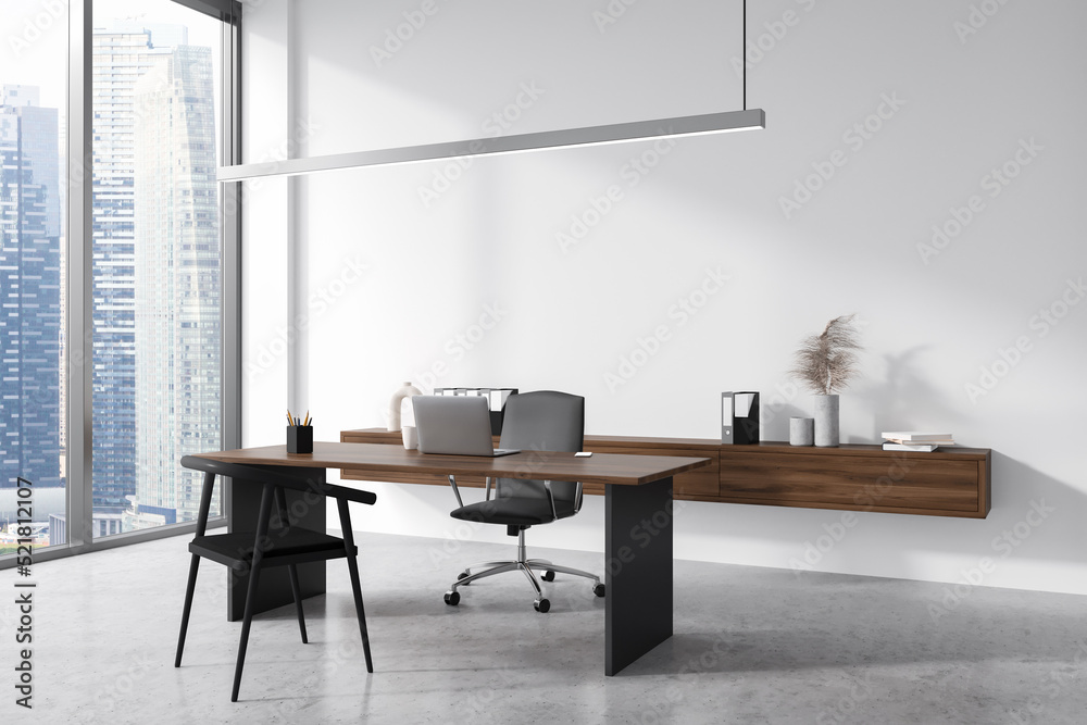 Light business interior with table and laptop, drawer with decoration and window Light business interior with table and laptop, drawer with decoration and window