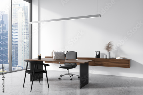 Light business interior with table and laptop, drawer with decoration and window