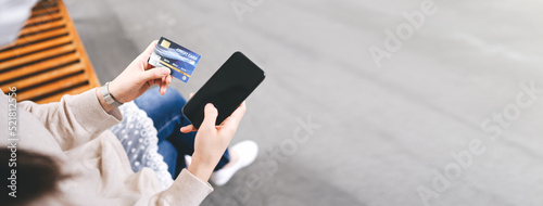 Obraz na plátně Adult woman consumer using creadit card and smartphone shopping via online application for spending money cashless