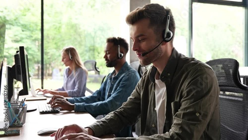 Male representative call center agent in wireless headset helping client, operator working in customer support service