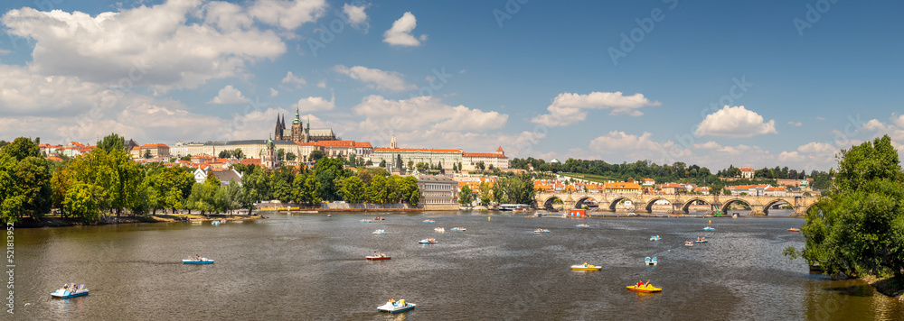 waterfront view across the river Vltava with pedal boats to Prague Castle and Charles Bridge, Prague, Czech republic