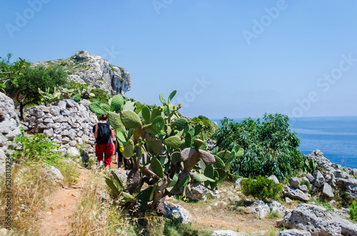 Escursionisti in cammino lungo il Sentiero delle Cipolliane che corre lungo la costa del Salento fra Marina di Novaglie e il Ciolo photo