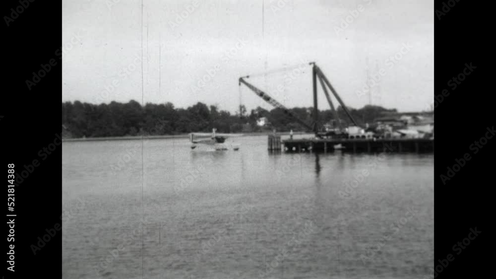 Float Plane Retrieval 1931 - A crane hoists a biplane out of the water at the US Naval Academy in Annapolis, Maryland in 1931. 