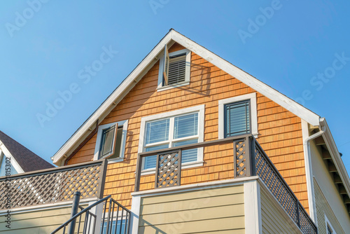 Low angle view of a house with wood shingles wall sidings and side hinged windows