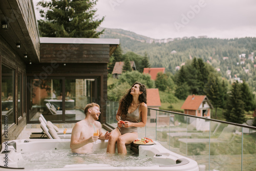 Young couple enjoying in outdoor hot tub on vacation © BGStock72