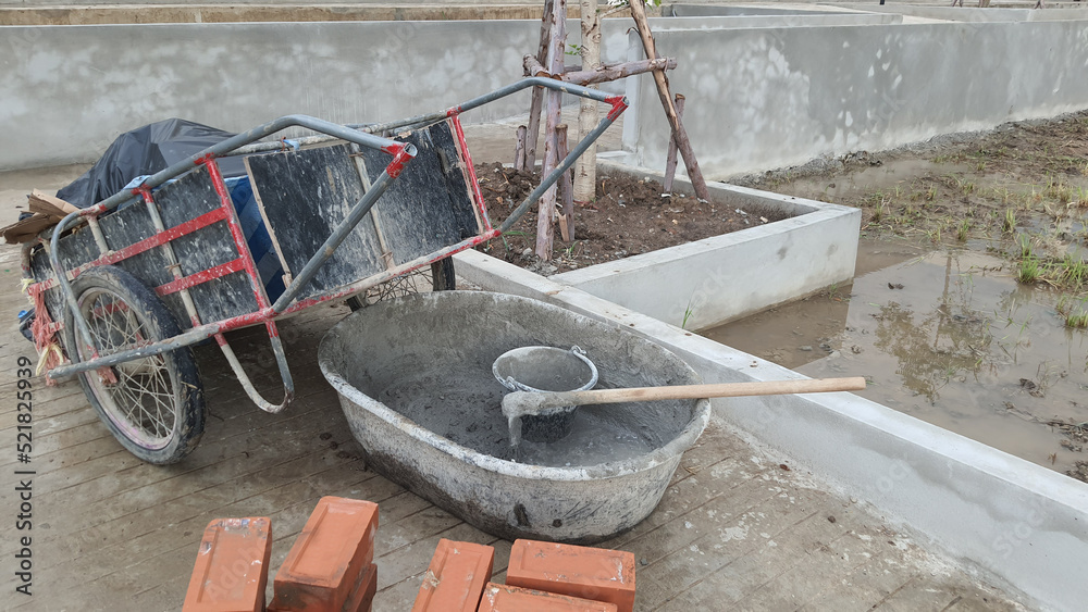 A pile of building materials, bucket mortar mixed and heap of red bricks at construction site. A pile of building materials, bucket mortar mixed and heap of red bricks at construction site.
