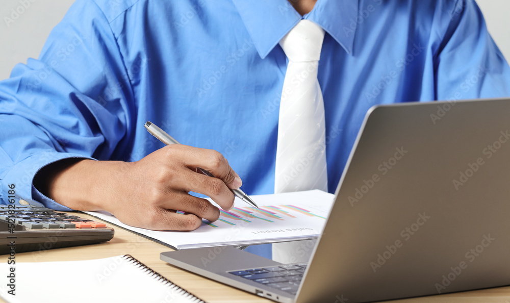 Fototapeta premium Businessman analyzing business plan documents and laptop computer on desk. Work planning concept
