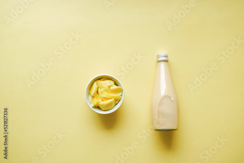 mango smoothie and fresh mango on yellow background 