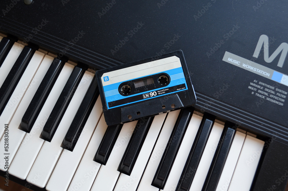 Vintage audio tape cassette on a synthesizer keys from above,Retro