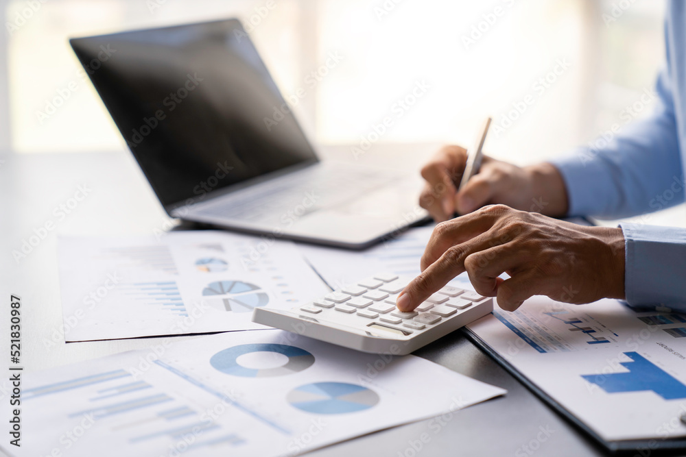 Fototapeta premium crop shot of image young man hand calculating monthly expenses finance and investment, accounting, calculating taxes, the corporate financial report of a company