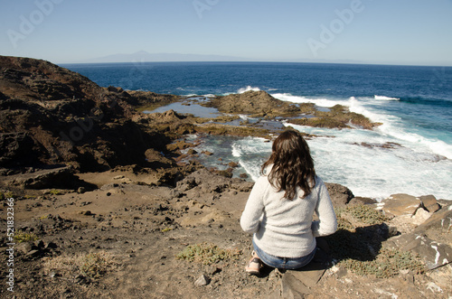 Valokuva Woman and coastal landscape with the island of Tenerife to the background