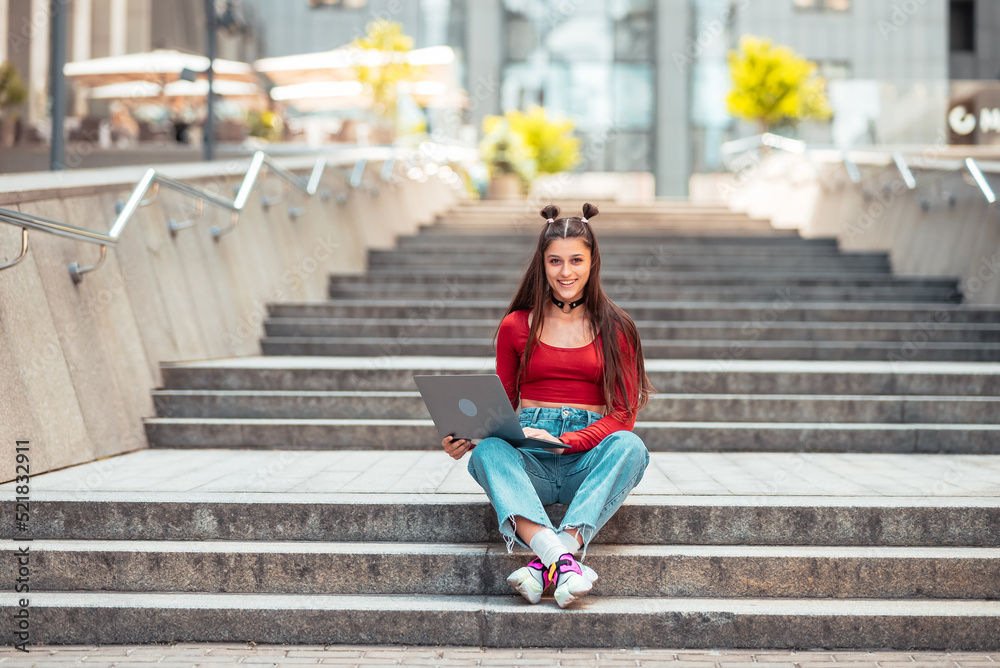 Beautiful young woman on the street using laptop Beautiful young woman on the street using laptop