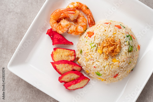 Yangzhou fried rice is a popular Chinese-style wok fried rice dish. Asia Chinese China food cuisine. Authentic Yangzhou fried rice with egg, fresh prawn and Red Roast Pork. photo