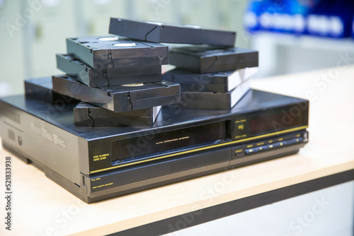 Pile of video cassette tape VHS on video playback stack concept of old retro style or vintage electric and electronic appliances multimedia record player device old fashioned.