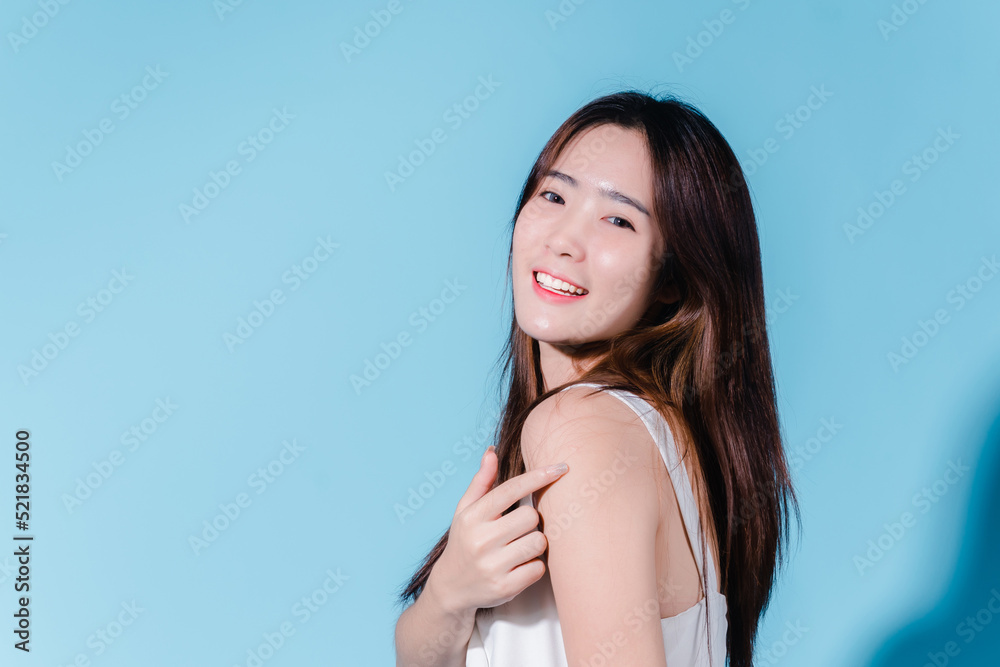 Charming asian beauty woman hold sun cream with sun protection uv or sunscreen on the blue background Charming asian beauty woman hold sun cream with sun protection uv or sunscreen on the blue background