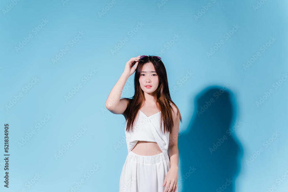 Charming asian beauty woman hold sun cream with sun protection uv or sunscreen on the blue background Charming asian beauty woman hold sun cream with sun protection uv or sunscreen on the blue background