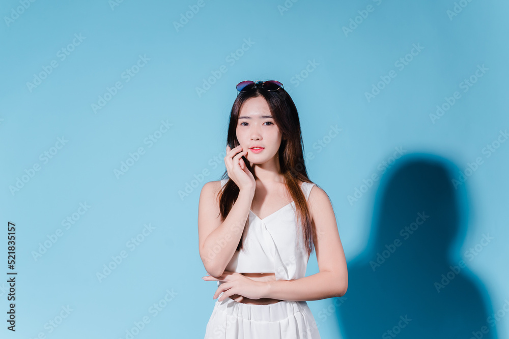 Charming asian beauty woman hold sun cream with sun protection uv or sunscreen on the blue background Charming asian beauty woman hold sun cream with sun protection uv or sunscreen on the blue background