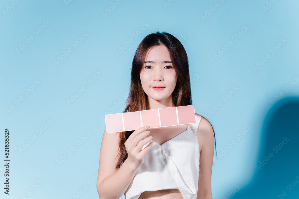 Charming asian beauty woman take color scale on the blue background Charming asian beauty woman take color scale on the blue background