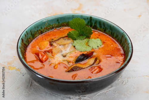 tom yum soup in a green plate on a white background

