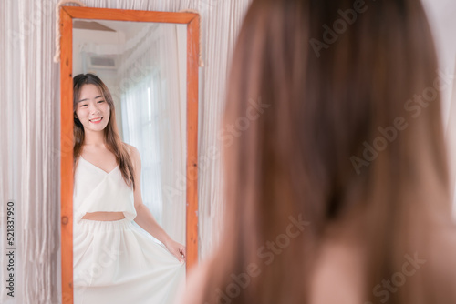 Asian woman choosing clothes dress-up mirror at home fashion lifestyle, Shopping concept.