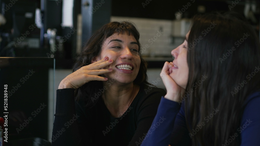Fototapeta premium Happy women in conversation at cafe restaurant. Two people talking casually