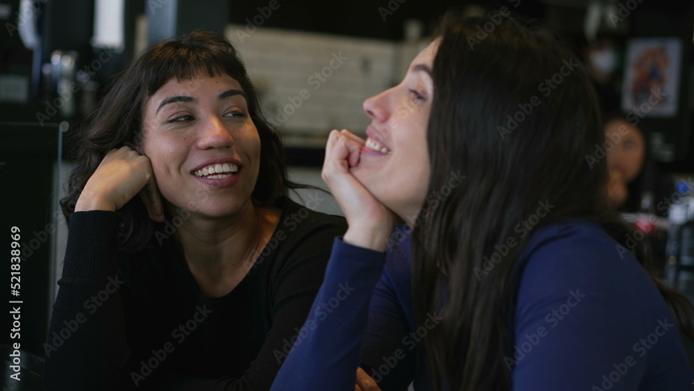 Naklejka premium Happy women in conversation at cafe restaurant. Two people talking casually