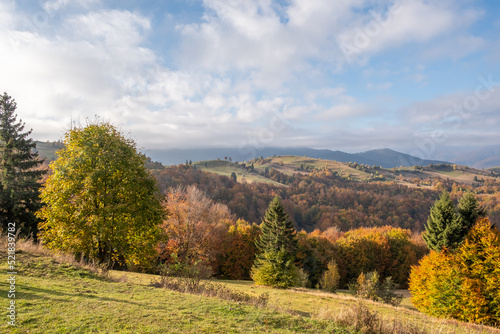 carpathian landscape in october. hills and mountain range in warm sunny weather with low clouds in the sky in autumn © valerii kalantai