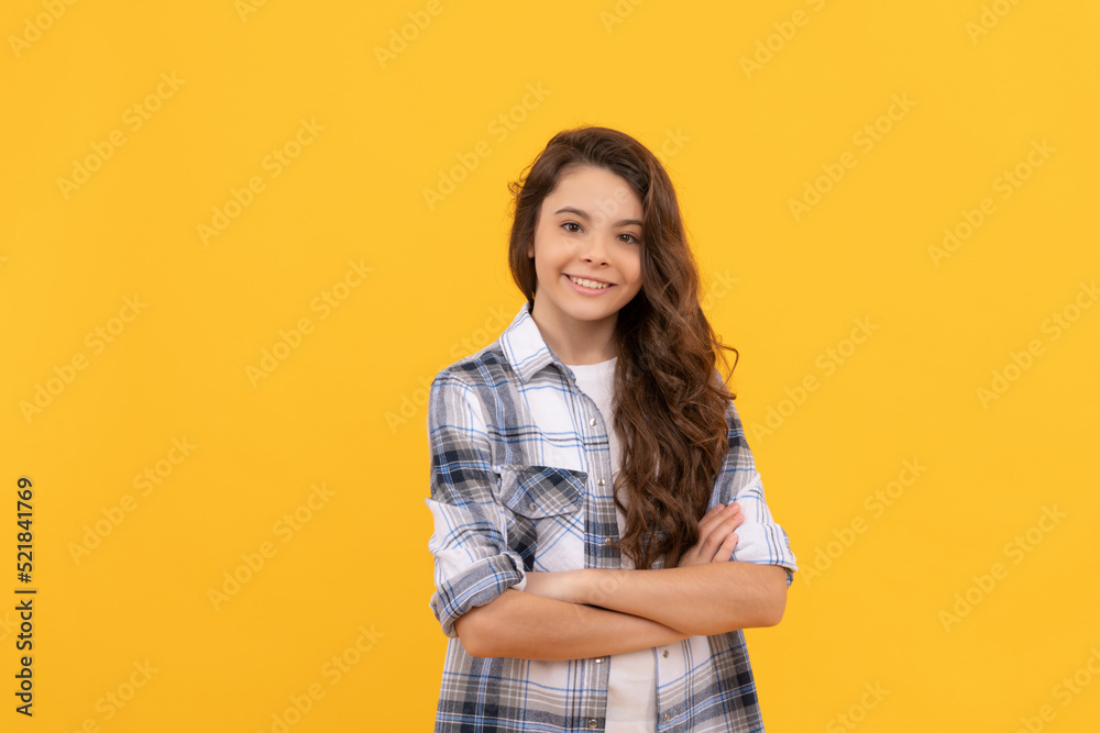 happy teen girl in checkered shirt with long curly hair on yellow background happy teen girl in checkered shirt with long curly hair on yellow background