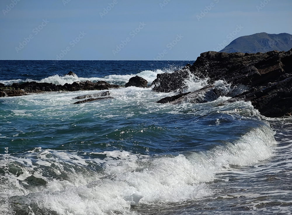 summer fun dynamic waves breaking on rocks blue sky and sunshine
