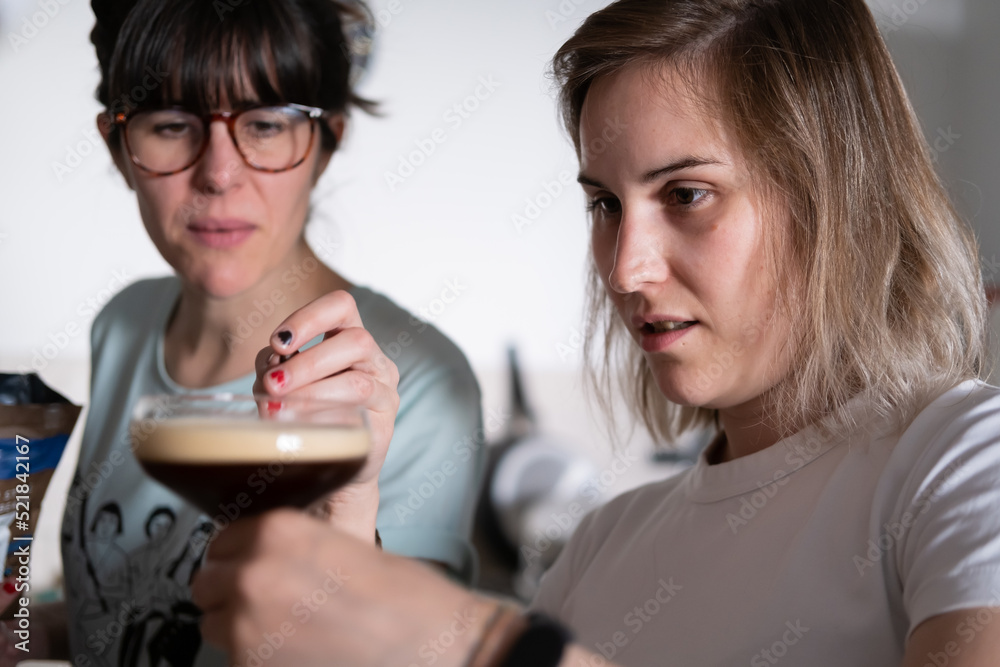 A lesbian couple making cocktails together at home A lesbian couple making cocktails together at home