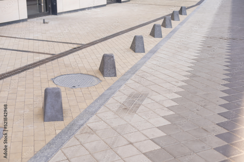 Obraz premium Pavement repair and laying of paving slabs on the walkway, stacked tile cubes on the background. Laying paving slabs in the pedestrian zone of the city, sand filling. Road tiles and curbs.