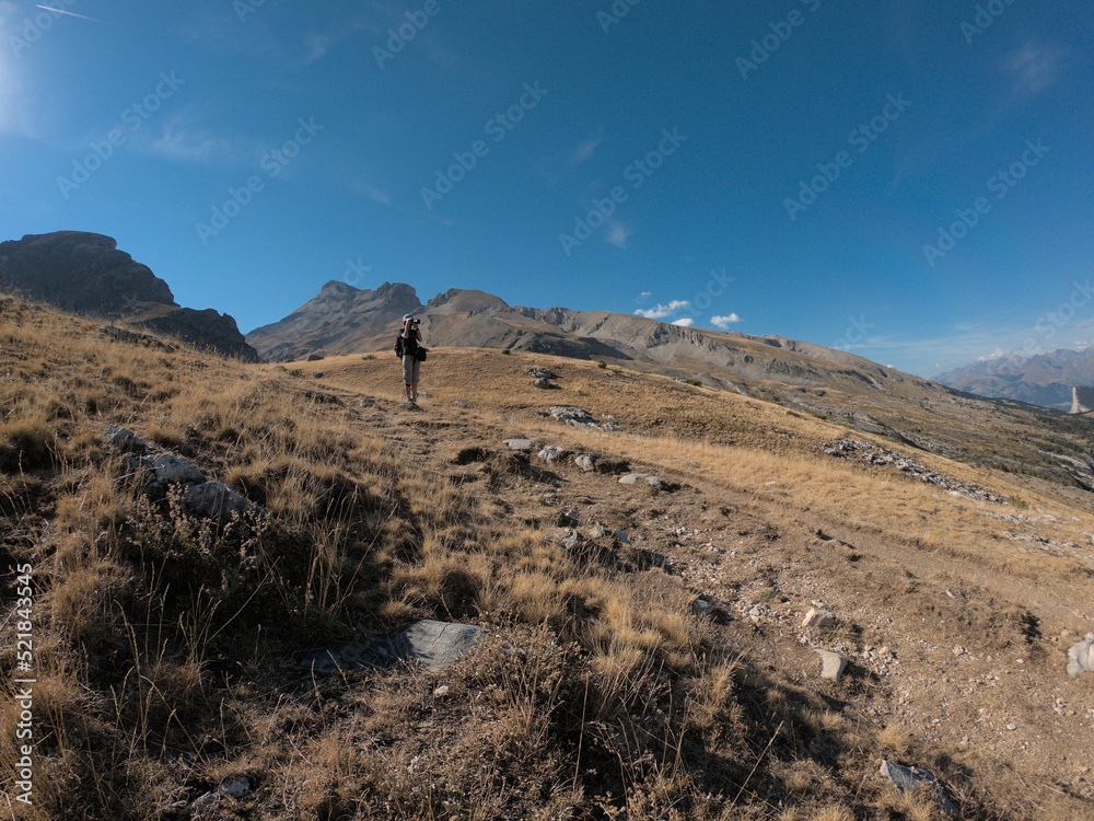 young caucasian photographer standing and shooting photos in green landscape with blue sky and small clouds. Grand ferrand mountain.
August 2022 | Vallon de Charnier | Dévoluy | Hautes Alpes | France