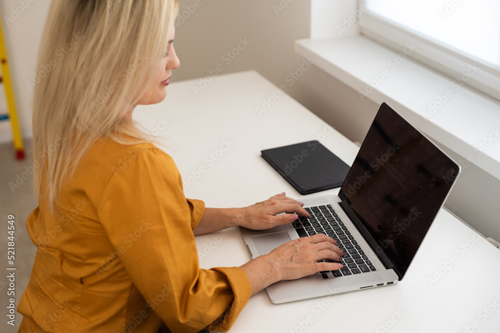 Fototapeta premium Image of young beautiful joyful woman smiling while working with laptop in office.