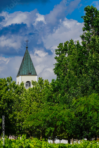 Tower of the church of St. James rising above the crowns of trees