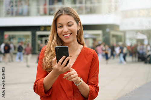 Photography Portrait of smiling young woman using a smartphone app in Berlin, Germany