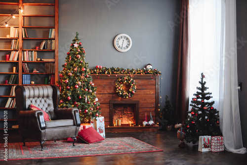 Christmas Dark Interior. Evergreen Christmas Tree with Red Decor. Fireplace, Armchair and Bookcase