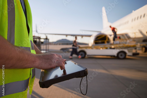 Fototapeta Member of ground crew preparing airplane before flight