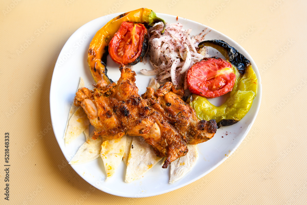 A skewered chicken kebob with grilled onions, bell peppers and delicious white meat with seasoning isolated on a white background. Tavuk sis, Tavuk izgara.