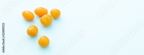 Fresh yellow cherry tomatoes on blue background