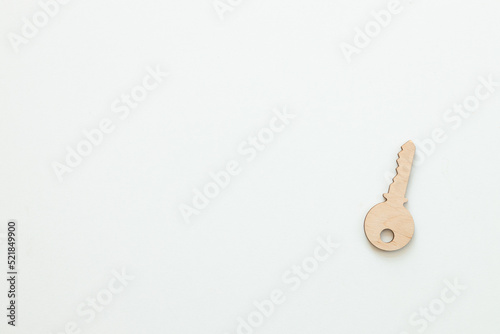 Wooden key on white wooden background, buying new house real estate concept © ALEXSTUDIO