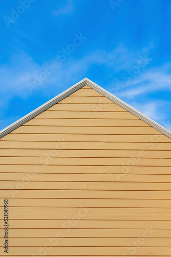 Peak of a house with tan wood vinyl lap sidings in San Francisco  California