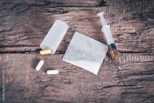 white powder, capsules and syringe on the table