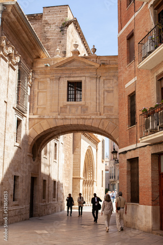 Rear view on people walking in the street of old town. Tourism in Europe concept in Valencia, Spain. © Dina