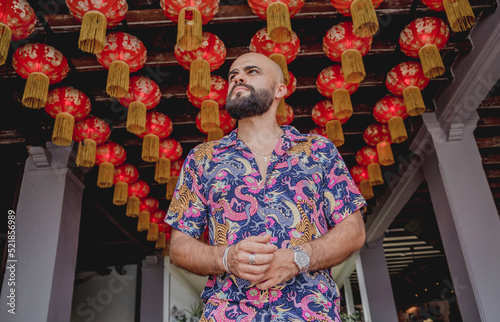 Canvas Print Young man with a backpack on the background of an asian temple