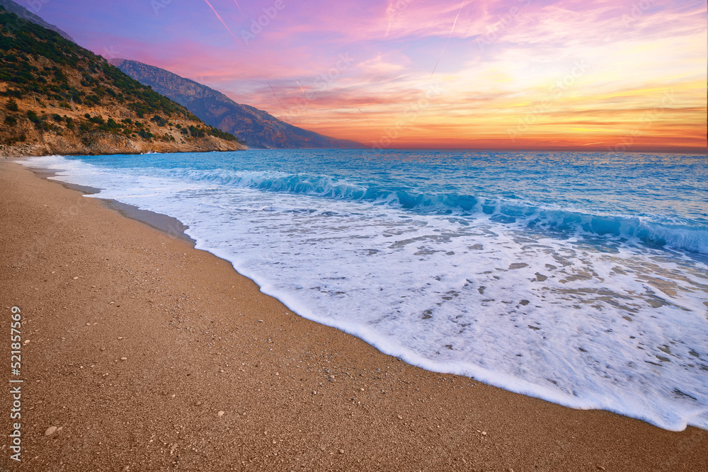Landscape of beach with idyllic sunset gradient sky and blue sea with white foam