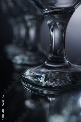 restaurant water glass leg details with reflection in black background 