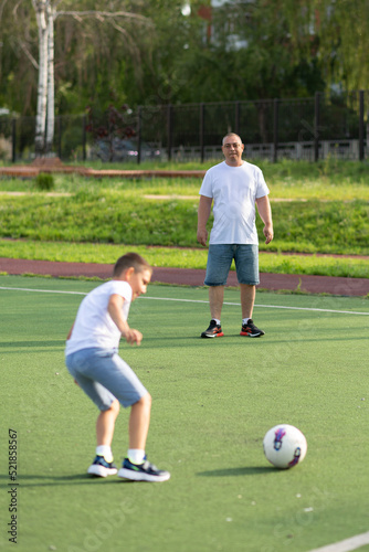 The son is preparing to score the ball to his father