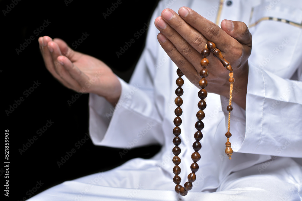 Obraz premium Religious muslim islam man in white session lift two hand for praying to Allah in mosque, isolated on dark background.concept for islamic pray, Ramadan, Eid al Fitr, eid ad-ha, meditation