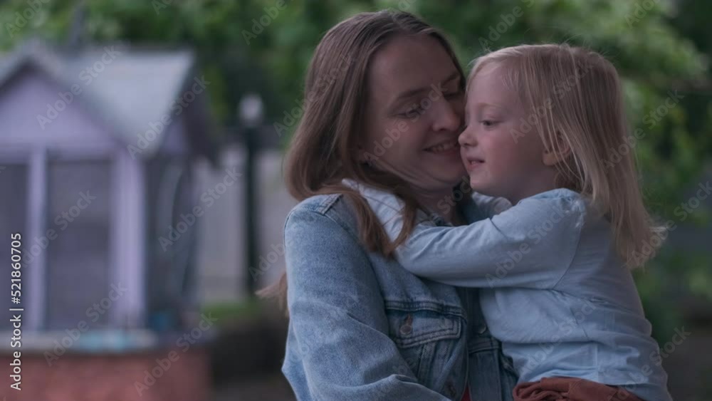 Mother talk with little daughter holding her in arms. Mom and child enjoy time together. Woman with child stay on veranda on rainy day Mother talk with little daughter holding her in arms. Mom and child enjoy time together. Woman with child stay on veranda on rainy day